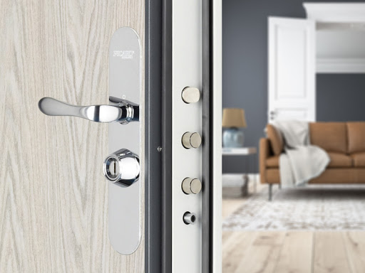 Serrurier qui installe une porte blindée